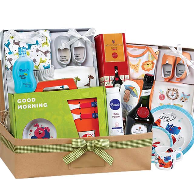 Baby hamper with clothes, baby care items, Benedictine DOM, tableware, and gift ribbon, ideal for flower delivery gifting.
