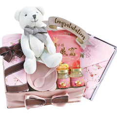 Congratulatory flower delivery hamper with teddy bear, pink gifts, and decorative bows.