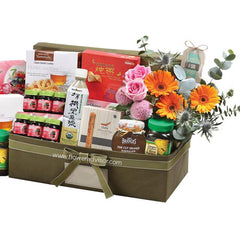 Flower delivery hamper with fresh roses, gerberas, and assorted gourmet treats in gift box