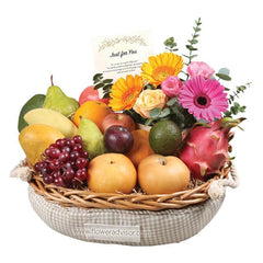 Flower delivery hamper with assorted fresh fruits and vibrant floral arrangement