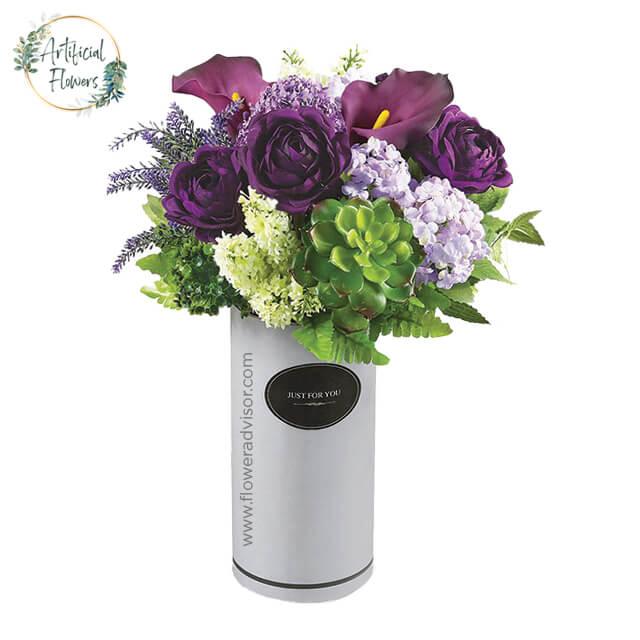 Artificial flower arrangement with purple roses and succulents in a vase for delivery