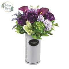 Artificial flower arrangement with purple roses and succulents in a vase for delivery