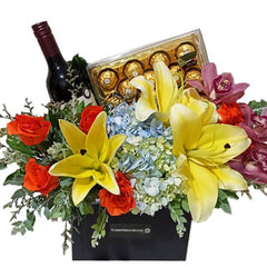 Flower delivery gift basket with fresh lilies, roses, hydrangeas, wine, and chocolates