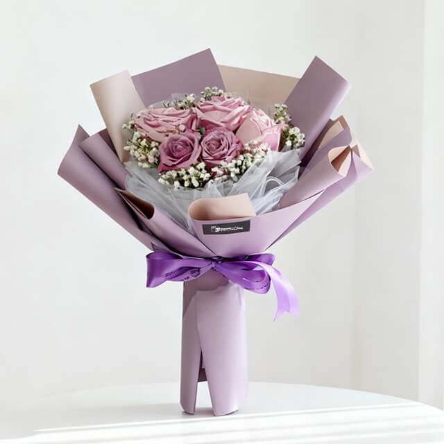 Elegant purple and pink rose bouquet with lilac wrapping, perfect for flower delivery in Singapore