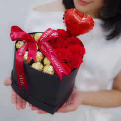 Heart-shaped flower arrangement with red roses and chocolates, ideal for flower delivery gifts