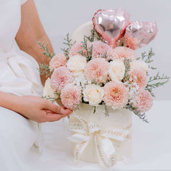 Elegant pink and white flower arrangement in hat box with heart balloons for delivery
