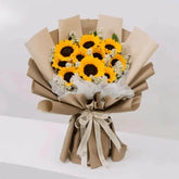 Sunflower bouquet with white daisies in kraft paper, ideal for flower delivery.