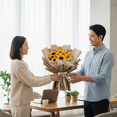 Sunflower bouquet with white daisies in kraft paper, ideal for flower delivery.