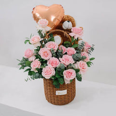 Flower delivery basket with pink roses, teddy bear, and heart balloon