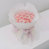 Elegant bouquet of pink roses arranged for flower delivery, wrapped in soft pastel paper.