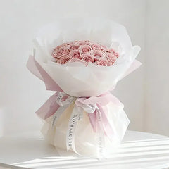 Pink rose bouquet wrapped in white paper with ribbon, perfect for flower delivery