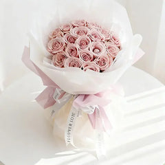 Pink rose bouquet wrapped in white paper with ribbon, perfect for flower delivery