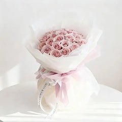 Pink rose bouquet wrapped in white paper with ribbon, perfect for flower delivery in Singapore