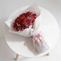 Red rose bouquet with baby's breath, elegantly wrapped for flower delivery