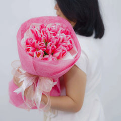 Hand holding bouquet of pink tulips, perfect for same-day flower delivery in Singapore