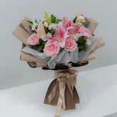 Elegant pink lily and rose bouquet for flower delivery, wrapped with ribbon and greenery