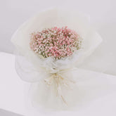 Pink baby’s breath bouquet in white wrapping, perfect for flower delivery in Singapore