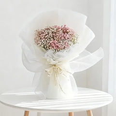 Delicate pink and white baby's breath bouquet wrapped in sheer white paper, perfect for flower delivery