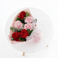Bouquet of red and pink roses for flower delivery, arranged with greenery and ribbon