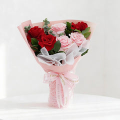Elegant bouquet of red and pink roses with greenery for flower delivery