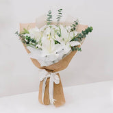 Elegant white lily bouquet with greenery, wrapped in burlap, ideal for flower delivery
