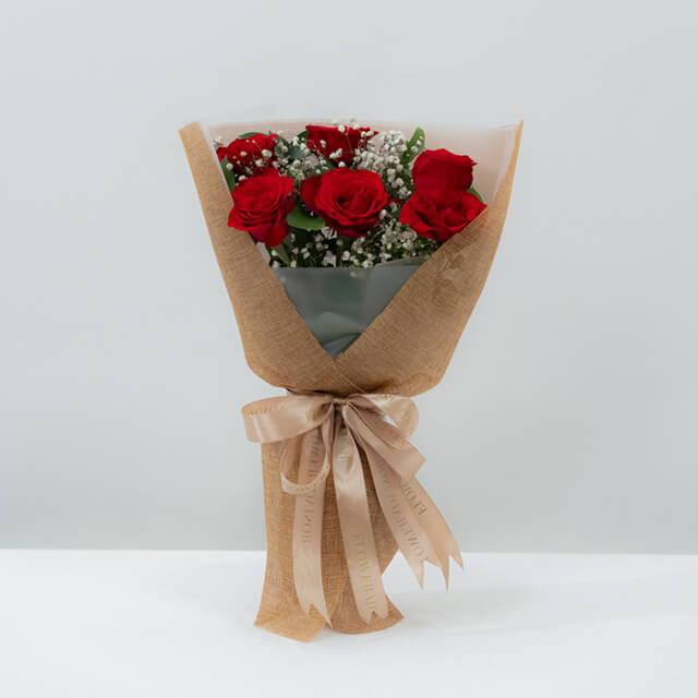 Elegant red rose bouquet wrapped in kraft paper for flower delivery in Singapore