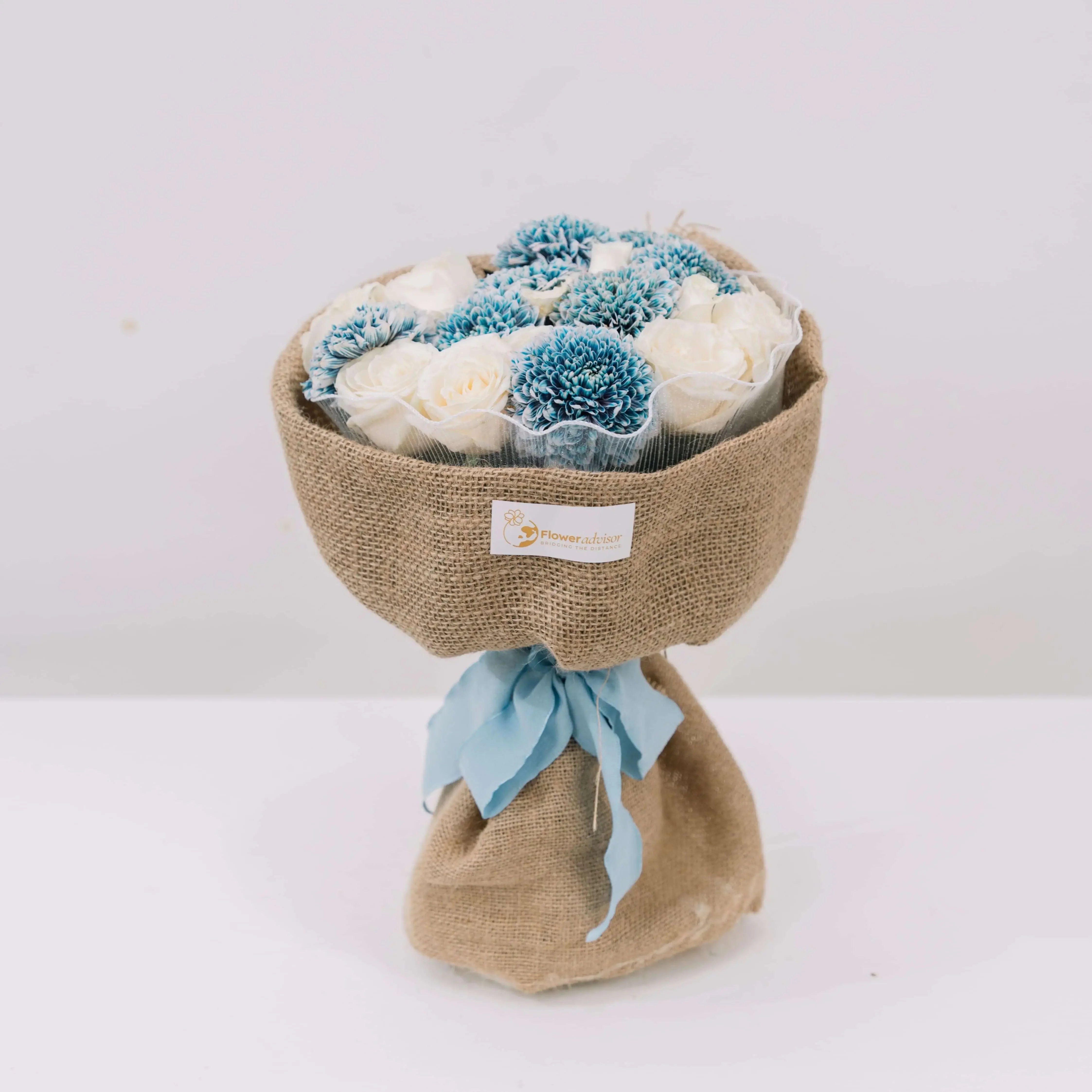 Rustic bouquet with blue and white flowers wrapped in burlap, ideal for flower delivery
