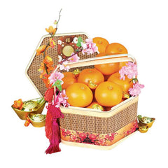 Festive flower delivery basket with mandarin oranges, pink blossoms, and gold ingots