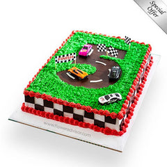 Race car themed birthday cake with green frosting track, toy cars, and checkered flags for delivery