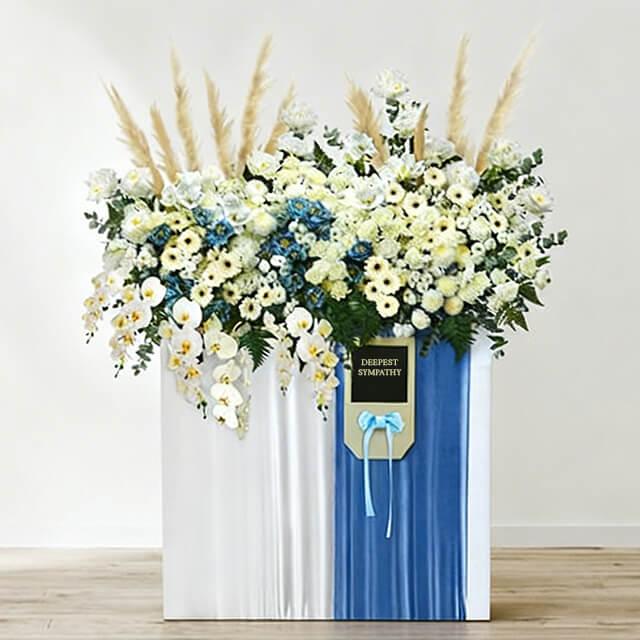 Large sympathy flower stand with white and yellow blooms for delivery in Singapore