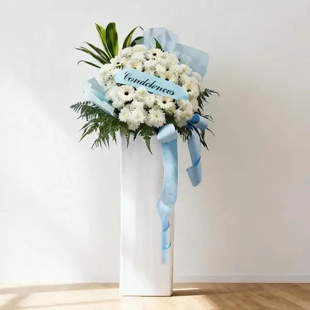 White condolence flower stand with blue ribbon for sympathy flower delivery