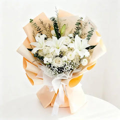 Elegant white lily bouquet with roses, wrapped in peach paper for flower delivery