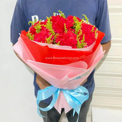 Bouquet of red carnations with greenery, wrapped in red and pink paper, for flower delivery