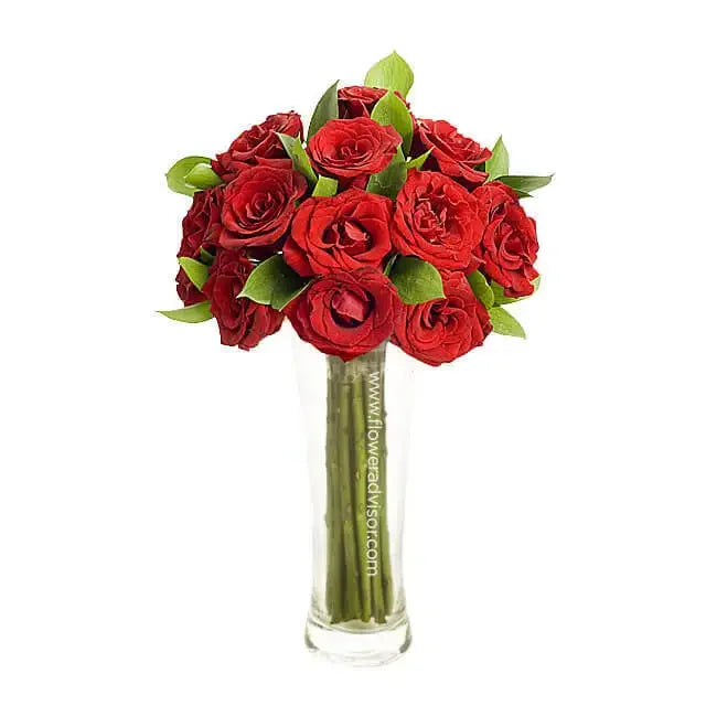 12 red roses in a clear vase with green leaves, perfect for flower delivery in Singapore