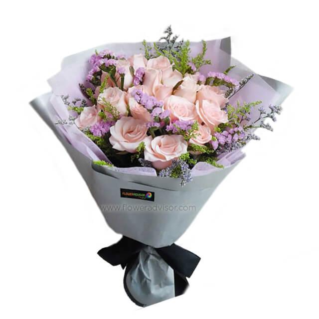 Peach rose bouquet with purple accents for flower delivery, wrapped in stylish paper