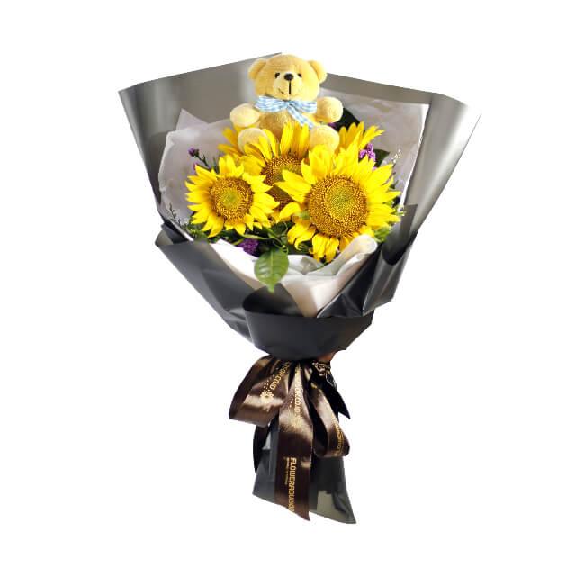Sunflower bouquet with five yellow sunflowers and a small teddy bear for flower delivery