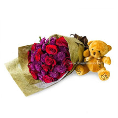 Bouquet of red roses and purple chrysanthemums with plush teddy bear for flower delivery