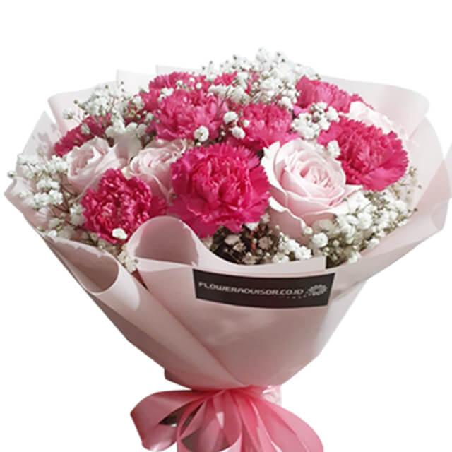 Hand bouquet with pink carnations, pale roses, and baby's breath for flower delivery
