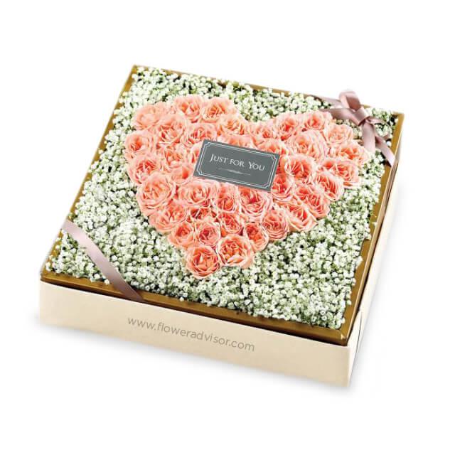 Heart-shaped pink rose flower arrangement in a gift box for flower delivery