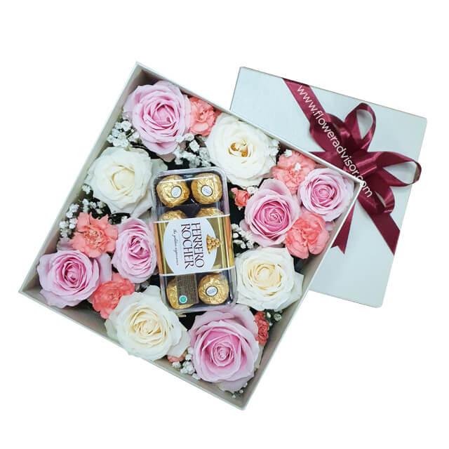 Flower delivery box with white and pink roses, carnations, and Ferrero Rocher chocolates