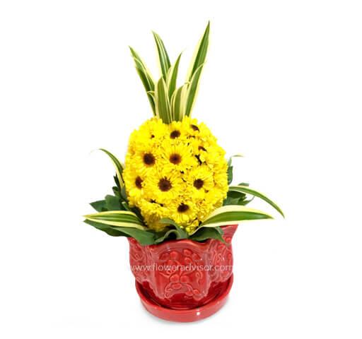 Bright yellow flower arrangement in a red vase for tropical-themed flower delivery