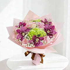 Hand bouquet with pink roses, purple orchids and green hydrangea for flower delivery