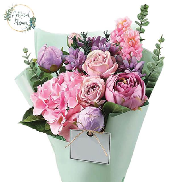 Pastel pink and purple artificial flower bouquet for flower delivery, wrapped in green paper