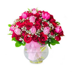 Fresh flower delivery of red roses and pink tulips in a glass vase, ideal for gifting.