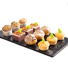Assorted gourmet cupcakes and mini desserts with floral decorations for flower delivery gift