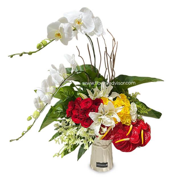 Fresh flower arrangement with red roses, yellow and white blooms in vase for delivery