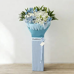 Blue and white condolence flower stand with lilies and roses for delivery