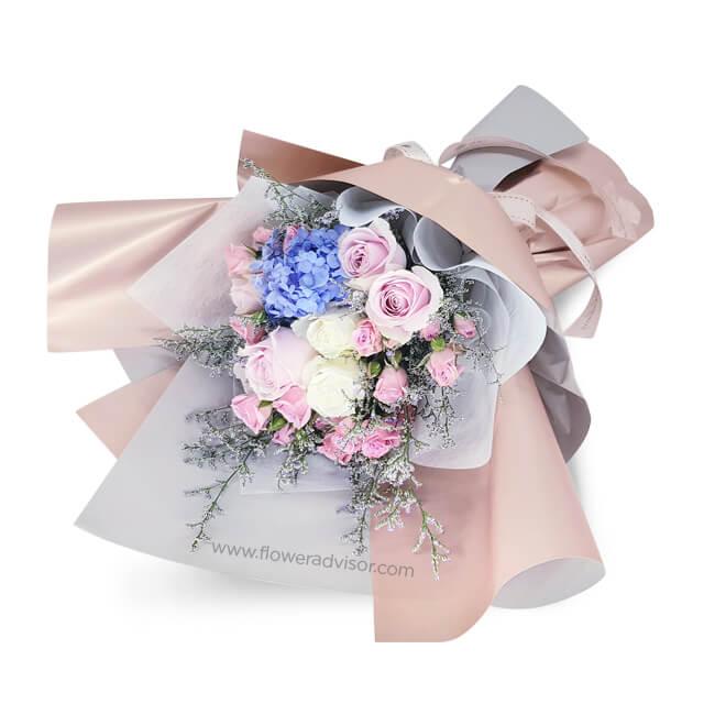 Elegant flower delivery bouquet with blue hydrangeas, pink roses, white roses, and pastel wrap