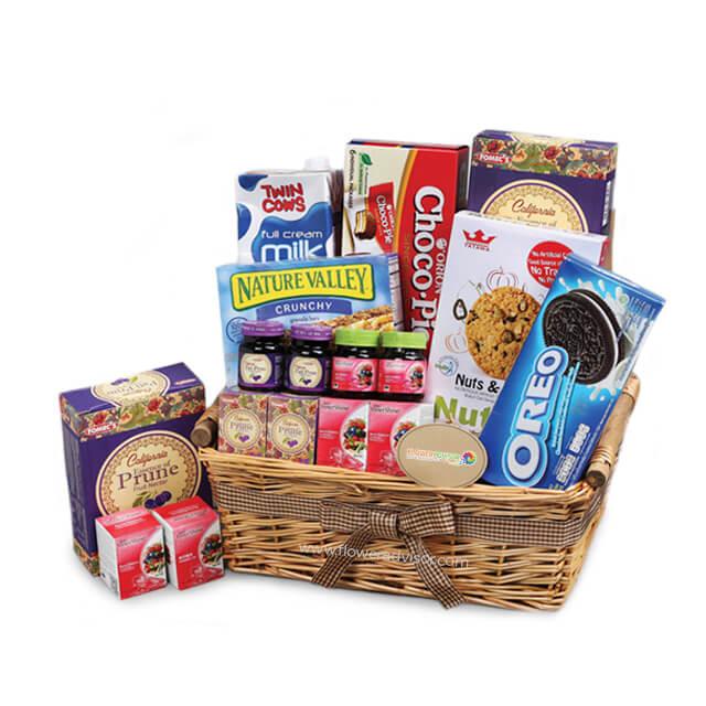 Gift hamper basket with assorted snacks and treats for flower delivery in Singapore