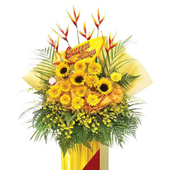 Grand opening flower stand with yellow gerberas, bird of paradise, and greenery for delivery